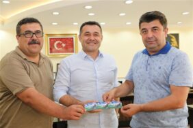 UĞUR’DAN BAŞKAN YÜCEL’E ANLAMLI HEDİYE  “1, 07, 82 NUMARALI” TEMSİLİ KOMBİNE KART